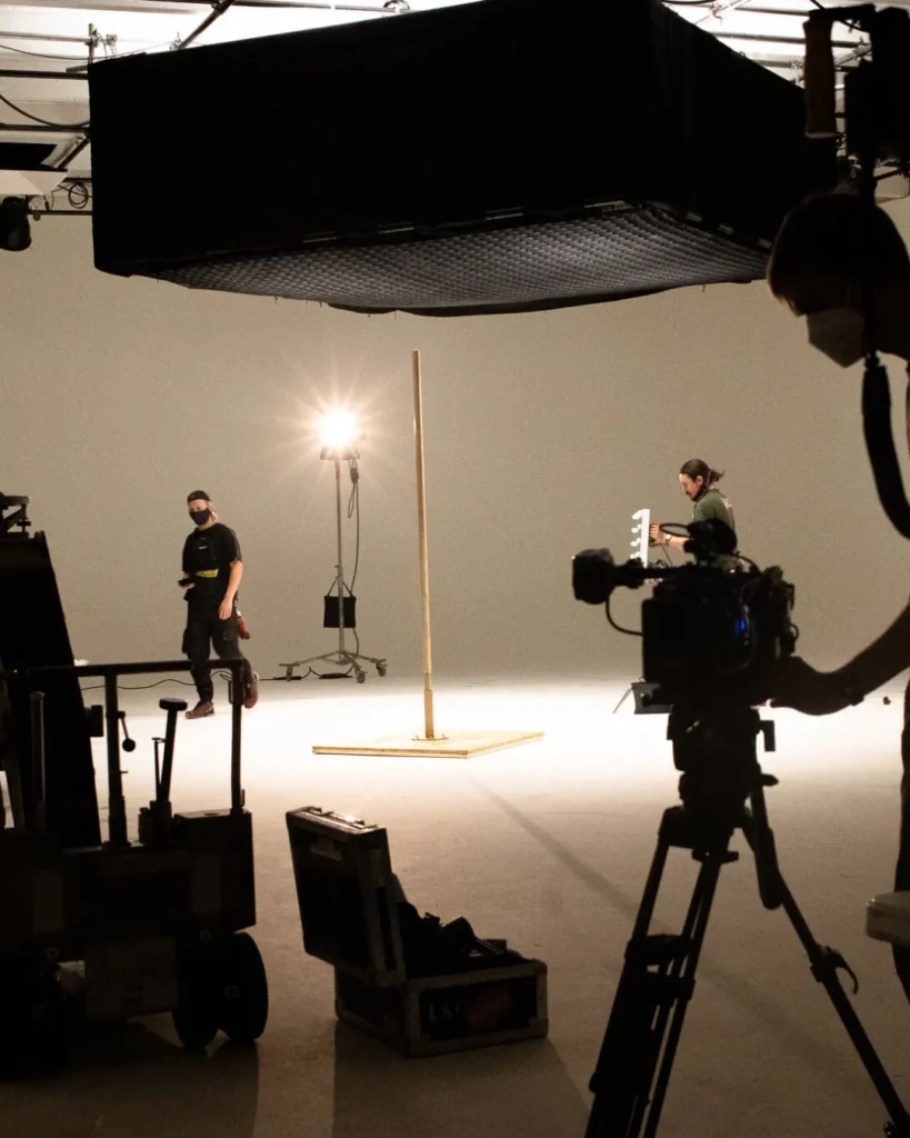 Film crew setting up lighting and camera equipment on a studio set during pre-production, highlighting the importance of storyboarding with the best storyboard software for filmmakers.